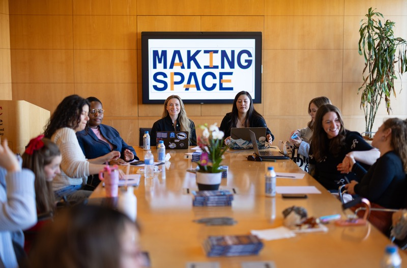 Making Space team gathered around a conference table with the Making Space logo displayed on a screen behind them.