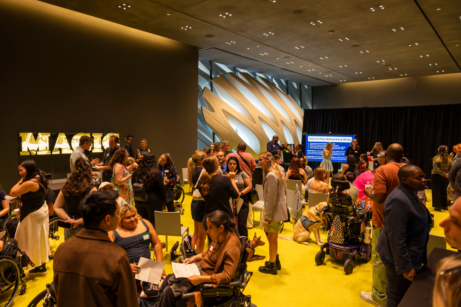 Networking event at The Broad museum with attendees on a bright yellow carpet.