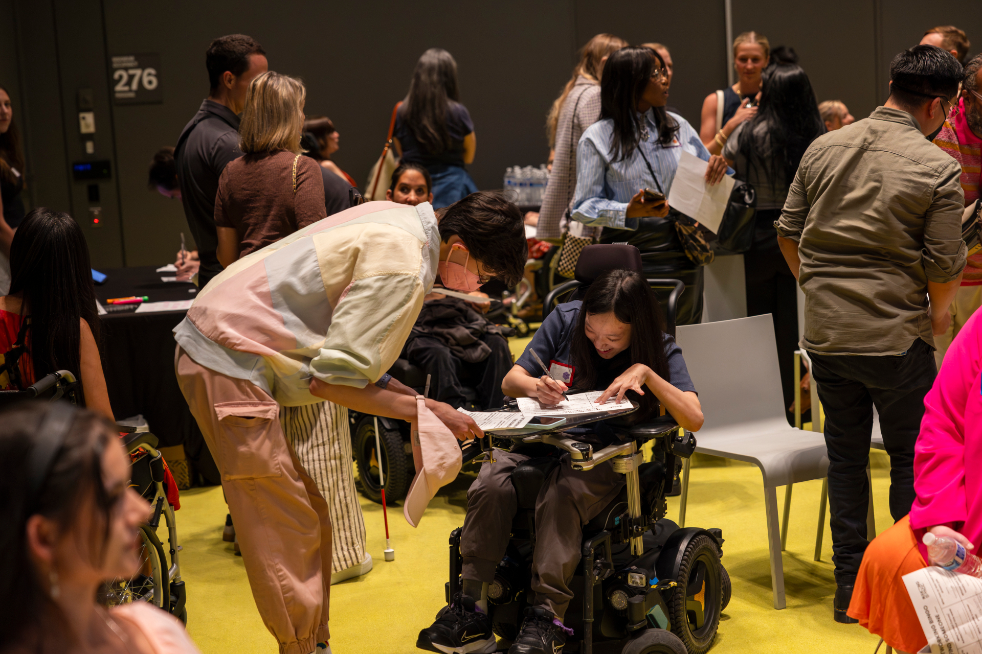 Two attendees filling out a networking bingo card together at a Making Space event.